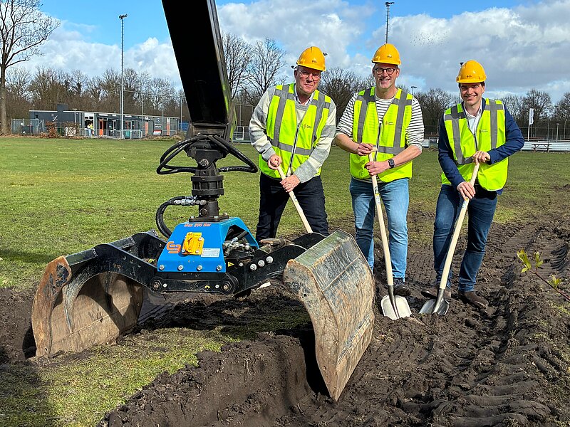 Bert de Graaf van korfbalvereniging Thrianta, Bouke Lesterhuis van hockeyvereniging HHC en wethouder sport Ronald Klok staan naast elkaar tijdens het moment van de eerste schop in de grond.