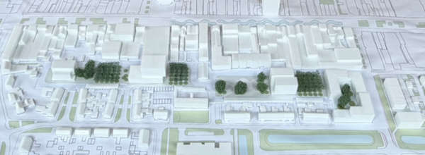 Foto van een maquette van de toekomstige inrichting van het Nicolaas Beetsplein en Bilderdijkplein in Hoogeveen. De maquette toont meerdere woongebouwen, groene zones met bomen, parkeerplaatsen, wegen en openbare ruimten, passend binnen de herontwikkeling van het gebied.
